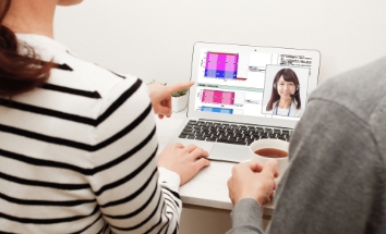 パソコンの画面を見る男女の画像